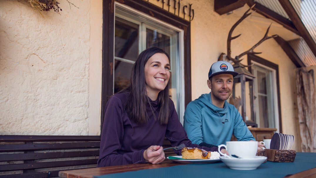 Einkehrschwung in Steinberg am Rofan Der Einkehrschwung lässt sich bei einem heißen Getränk und leckeren Nachtisch ganz besonders gut genießen. Das Paar macht eine Rast im Waldhäusl in Steinberg am Rofan.