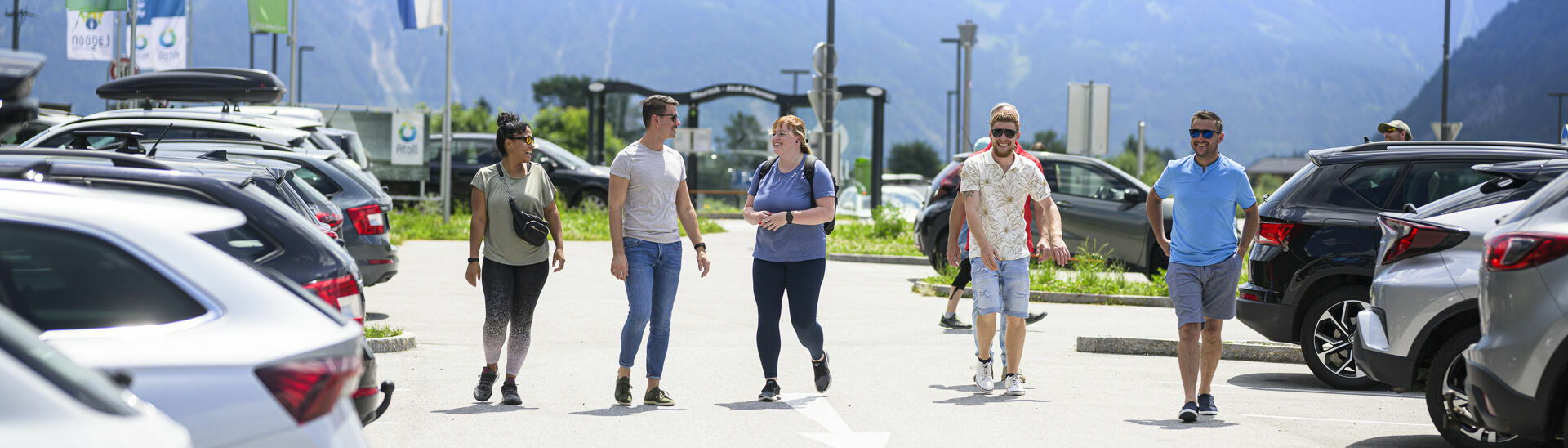 Freunde gehen beim Parkplatz des Atoll Achensee gemeinsam zum Auto.