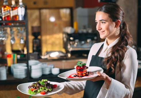 Ein Lehrling bedient in einem Restaurant.