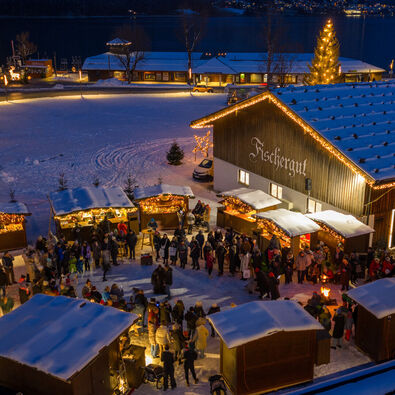 The Christmas market at Fischergut sparkles with lights and is surrounded by snow. Many visitors enjoy spending time there during the pre-Christmas season.