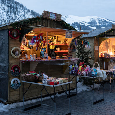 An der Schiffsanlegestelle Scholastika in Achenkirch am Achensee locken hell erleuchtete Marktstände mit Kunsthandwerk zur Landweihnacht. 