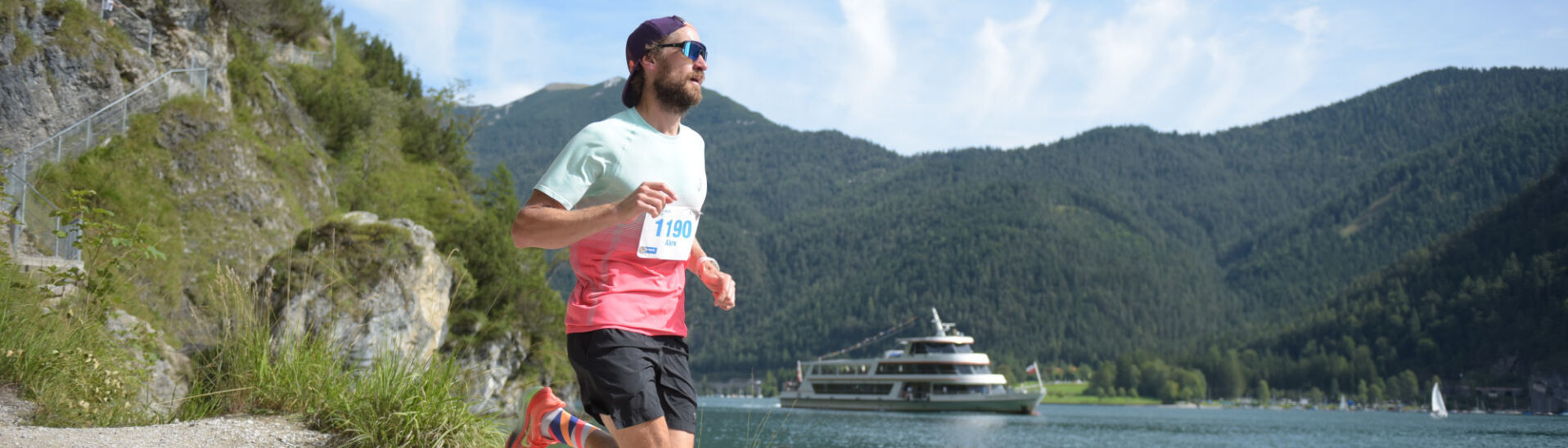 Ein Teilnehmer auf der Trail-Strecke des Achenseelaufs. Im Hintergrund ist die Achenseeschifffahrt zu sehen.