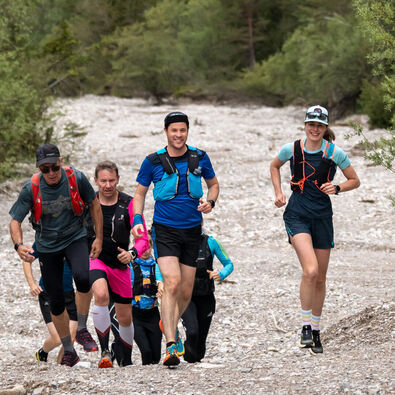 A group of runners out and about on gravel paths in the natural landscape of Lake Achensee.