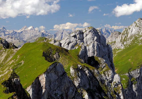 Das Rofangebirge besteht aus grüner Wiesenlandschaft und kargen Felsformationen.
