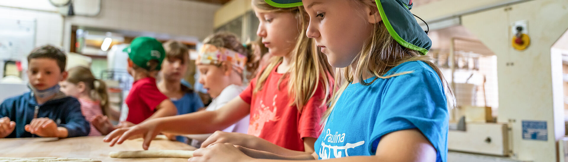 Der Tag beginnt frühmorgens in der Bäckerei Adler in Achenkirch. Hier dürfen Kinder in der Stube gemeinsam versuchen Brötchen zu backen.