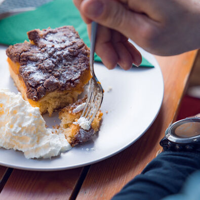Hot drinks and delicious cakes are perfect to refuel after your winter adventure. This couple enjoys a break in the Waldhäusl in Steinberg am Rofan.