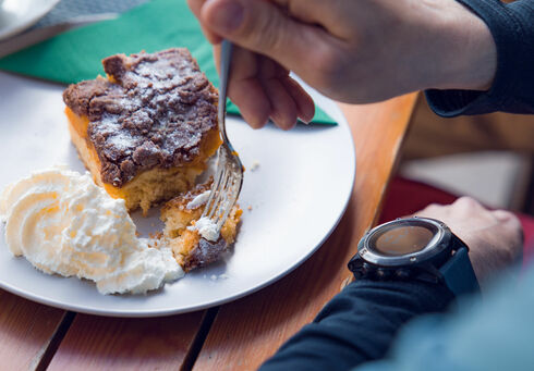 Der Einkehrschwung lässt sich bei einem heißen Getränk und leckeren Nachtisch ganz besonders gut genießen. Das Paar macht eine Rast im Waldhäusl in Steinberg am Rofan.