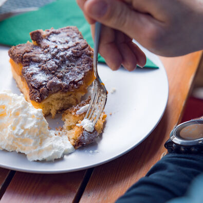 Der Einkehrschwung lässt sich bei einem heißen Getränk und leckeren Nachtisch ganz besonders gut genießen. Das Paar macht eine Rast im Waldhäusl in Steinberg am Rofan.