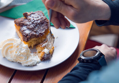 Der Einkehrschwung lässt sich bei einem heißen Getränk und leckeren Nachtisch ganz besonders gut genießen. Das Paar macht eine Rast im Waldhäusl in Steinberg am Rofan.