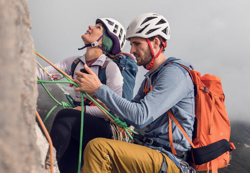 Ein Mann und eine Frau klettern am Südgrat des Gufferts bei nebeligem Wetter.