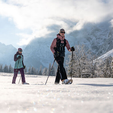 Zwei Freundinnen unternehmen bei herrlichem Wetter eine Schneeschuhwanderung im Falzthurntal im Naturpark Karwendel.