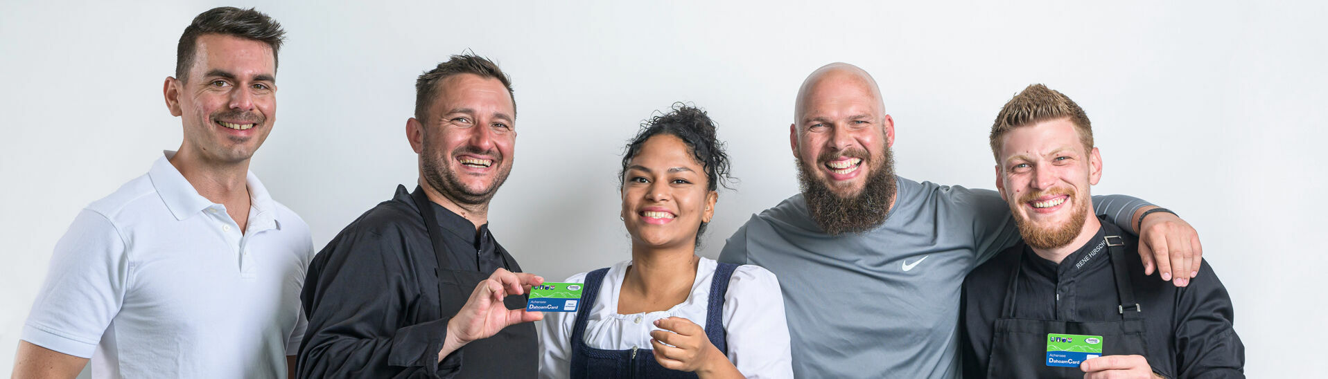/// This photo captures a massage therapist, a waitress, two chefs, and a fitness coach holding the Achensee region's benefit card for employees.