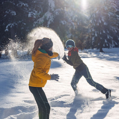 Two siblings romp in the freshly fallen snow and enjoy their time together in the Karwendel valleys in glorious sunshine.