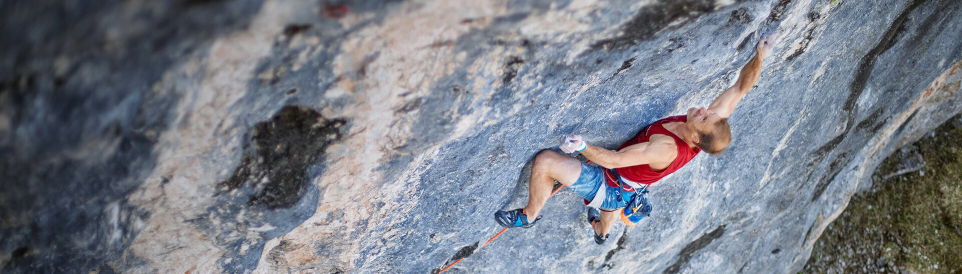 Ein Kletterer, der eine Steinwand des Klobenjoch im Rofangebirge hinaufklettert.