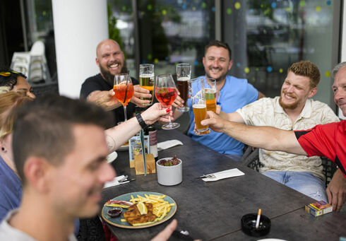 A group of friends toasts at the table of a restaurant on Lake Achensee.