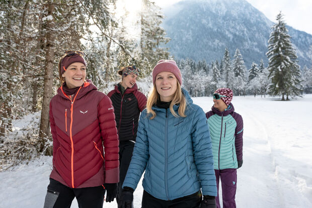 Eine Gruppe Freundinnen unternimmt bei herrlichem Wetter eine Winterwanderung im Gerntal im Naturpark Karwendel.
