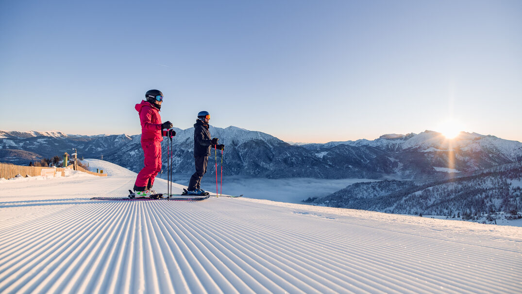 Bei strahlendem Wetter genießen zwei Skifahrer ihren Tag bei den Hochalmliften Christlum in Achenkirch am Achensee.