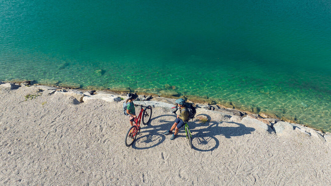 Ein Pärchen erkundet das Seeufer in Maurach am Achensee mit dem Bike.