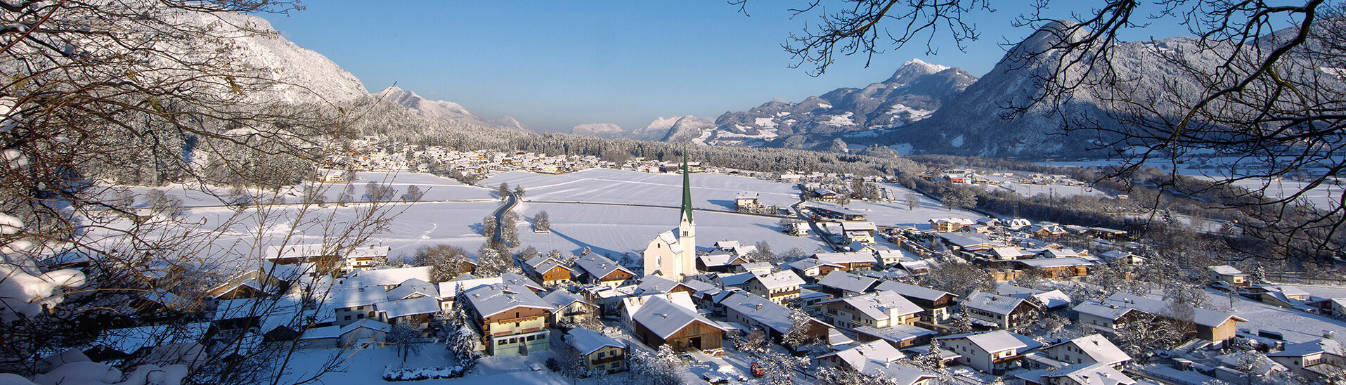 Eine Winteraufnahme vom Dorf Wiesing mit der Pfarrkirche Wiesing, welches im Inntal am Fuße der Achensee Region liegt.