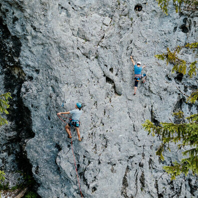 Two climbers enjoying the rugged rock face on Lake Achensee and practising lead climbing.