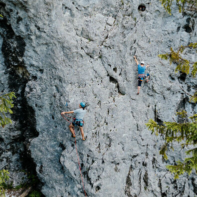 Zwei Kletterer beim Genießen der schroffen Felswand am Achensee und beim Üben des Vorstiegs.