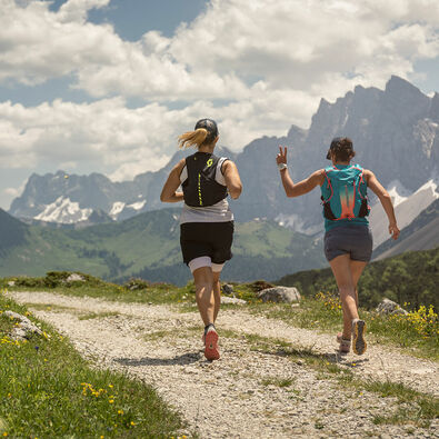 Trailrunner trainieren auf einer Forstsraße im Naturpark Karwendel in wunderschöner Umgebung.