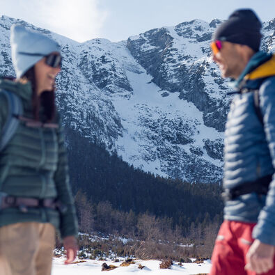 An einem sonnigen Tag die schneebedeckte Landschaft im Bergsteigerdorf Steinberg am Rofan bei einer Winterwanderung genießen.
