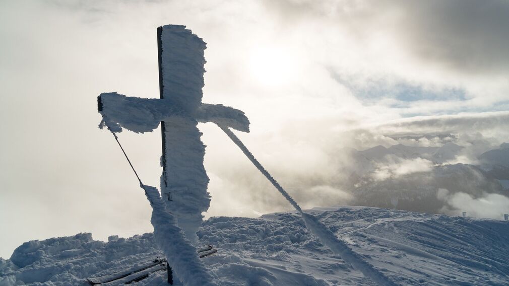 Skitour auf den Juifen mit dem schneebedeckten Gipfelkreuz.