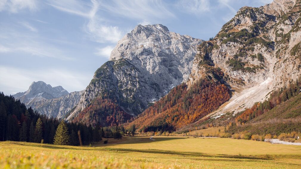 Das Falzthurntal im Naturpark Karwendel zeigt sich im Sommer von seiner schönsten Seite: Hohe, schroffe Berge ragen empor, umgeben von bunten Wiesen und malerischen Waldlandschaften.