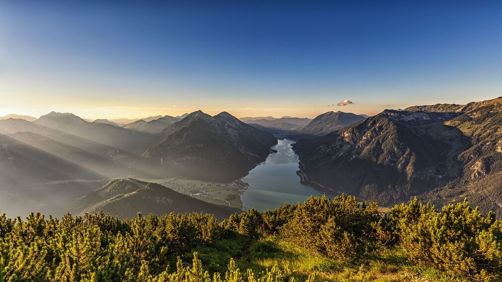 At the summit of the Bärenkopf, outdoor enthusiasts are rewarded with breathtaking views of Lake Achensee and the surrounding mountain landscape.