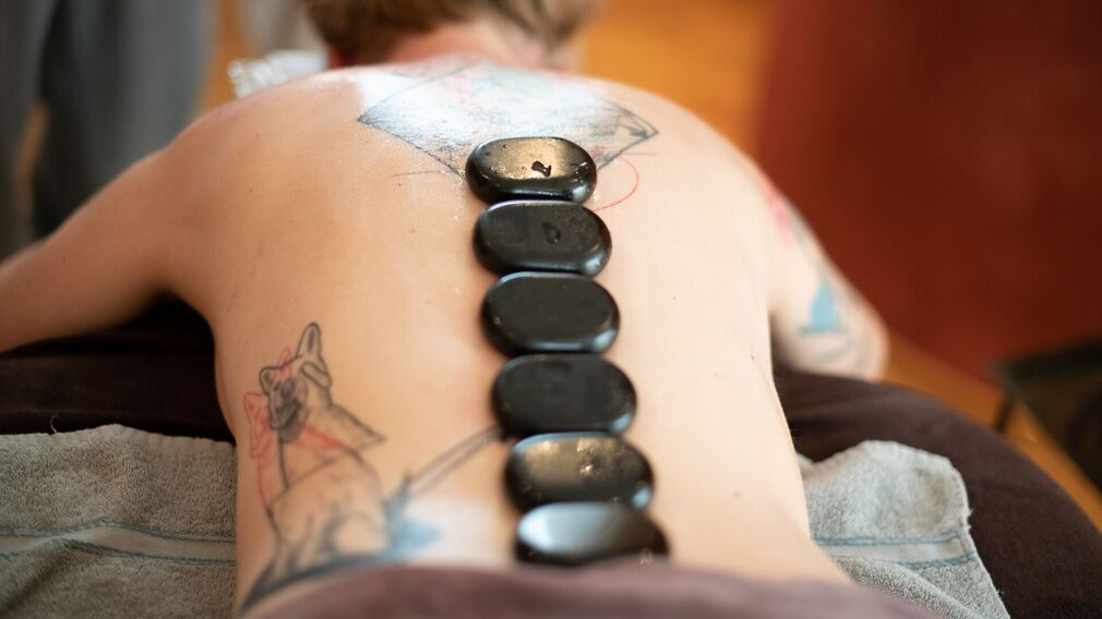 Wohltuende Entspannungsmassage mit warmen Steinen – sanfte Griffe und tiefe Wärme für pure Ruhe und Erholung.