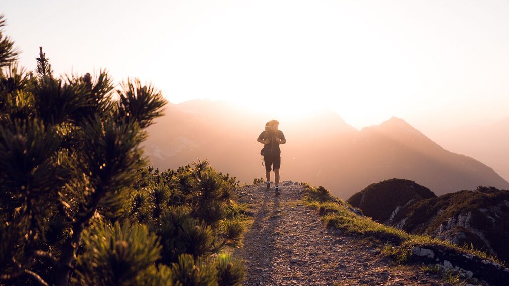 Sonnenaufgang am Bärenkopf (1.991 Meter) im Juni – rosarotes Morgenlicht über Achensee und Karwendel, Gipfel im sanften Farbenspiel.