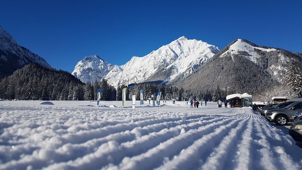 Dorfloipe in Pertisau mit der Pfarrkirche Pertisau und dem Karwendelgebirge im Hintergrund