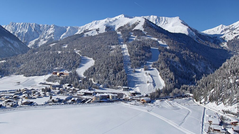 Winterliche Aufnahme vom Dorf Achenkirch am Achensee mit Blick auf das Skigebiet Hochalmlifte Christlum.