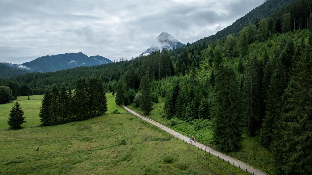 Zwei Mountainbikerinnen entspannen nach ihrer Tour zur Gufferthütte in Liegestühlen und genießen einen frisch servierten Kaiserschmarrn.