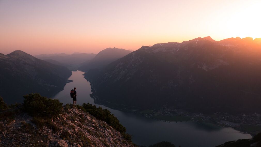 Sonnenaufgang am Bärenkopf (1.991 Meter) im Juni – rosarotes Morgenlicht über Achensee und Karwendel, Gipfel im sanften Farbenspiel.